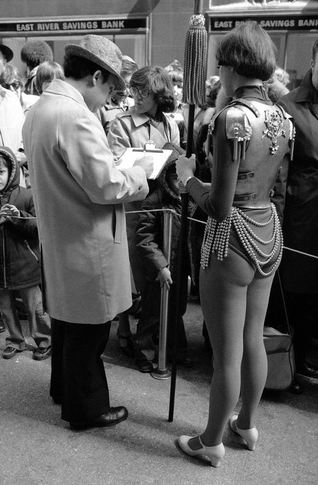 Rockette Cindy Peiffer, dressed in armor suit, waits outside Radio City Music Hall, 1978.