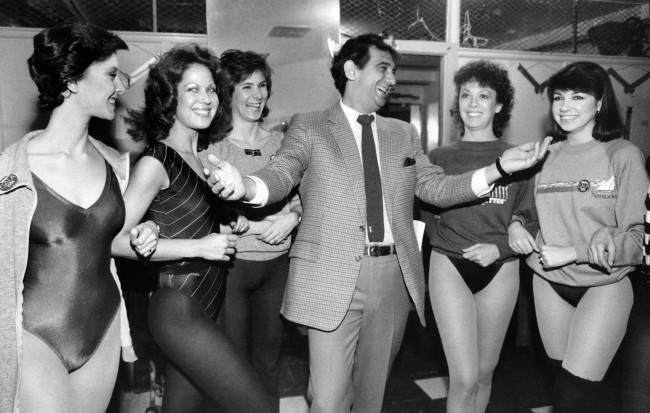 Singer Placido Domingo shares a laugh with members of the Rockettes, 1984.