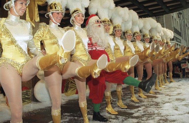 Santa Claus, also known as Charles Edward Hall, kicks up his heels along with the Radio City Music Rocketts, 1991.