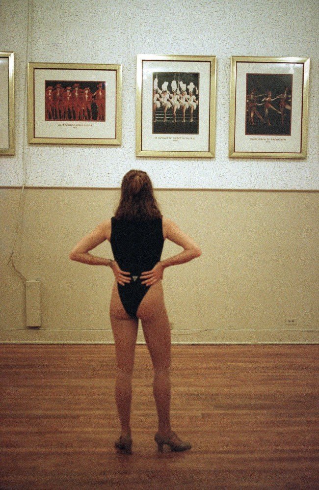 A Rockette hopeful looks at pictures of the dance troupe while waiting her turn to strut her stuff before a panel of judges, 1993.