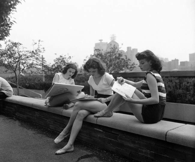 Three Rockettes sketch the skyline between shows on the play roof of Radio City Music Hall, 1951.