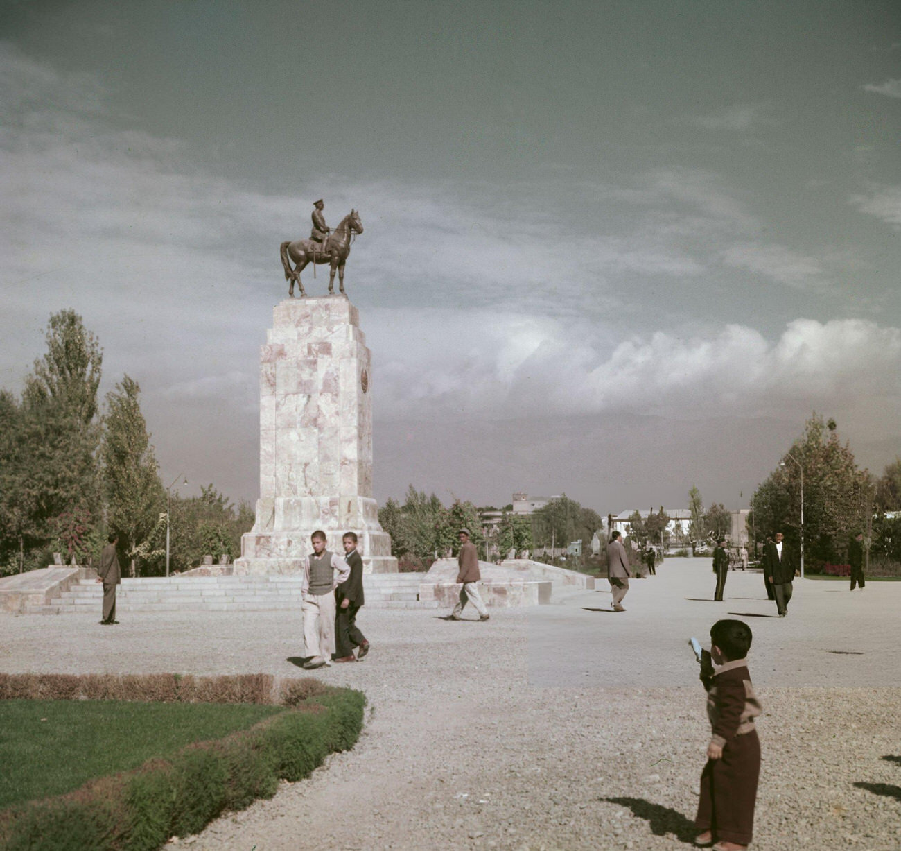 Pedestrians walk past an equestrian statue of Mohammad Reza Pahlavi, Shah of Iran, in a main square in the city of Tehran, 1960s.