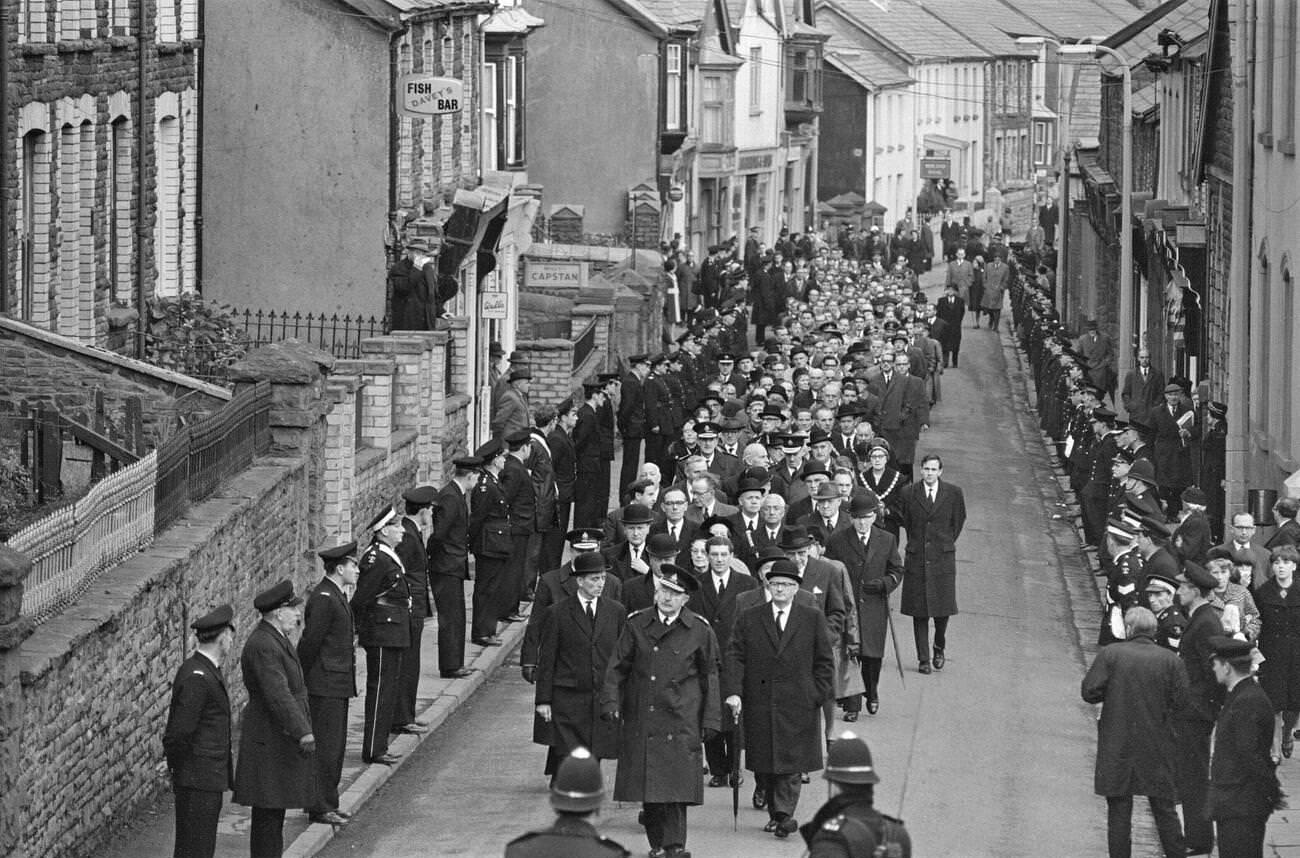 Mourners walk through the streets on their way to the cemetery to attend the mass funeral for victims of the Aberfan mud slide disaster, 1966.