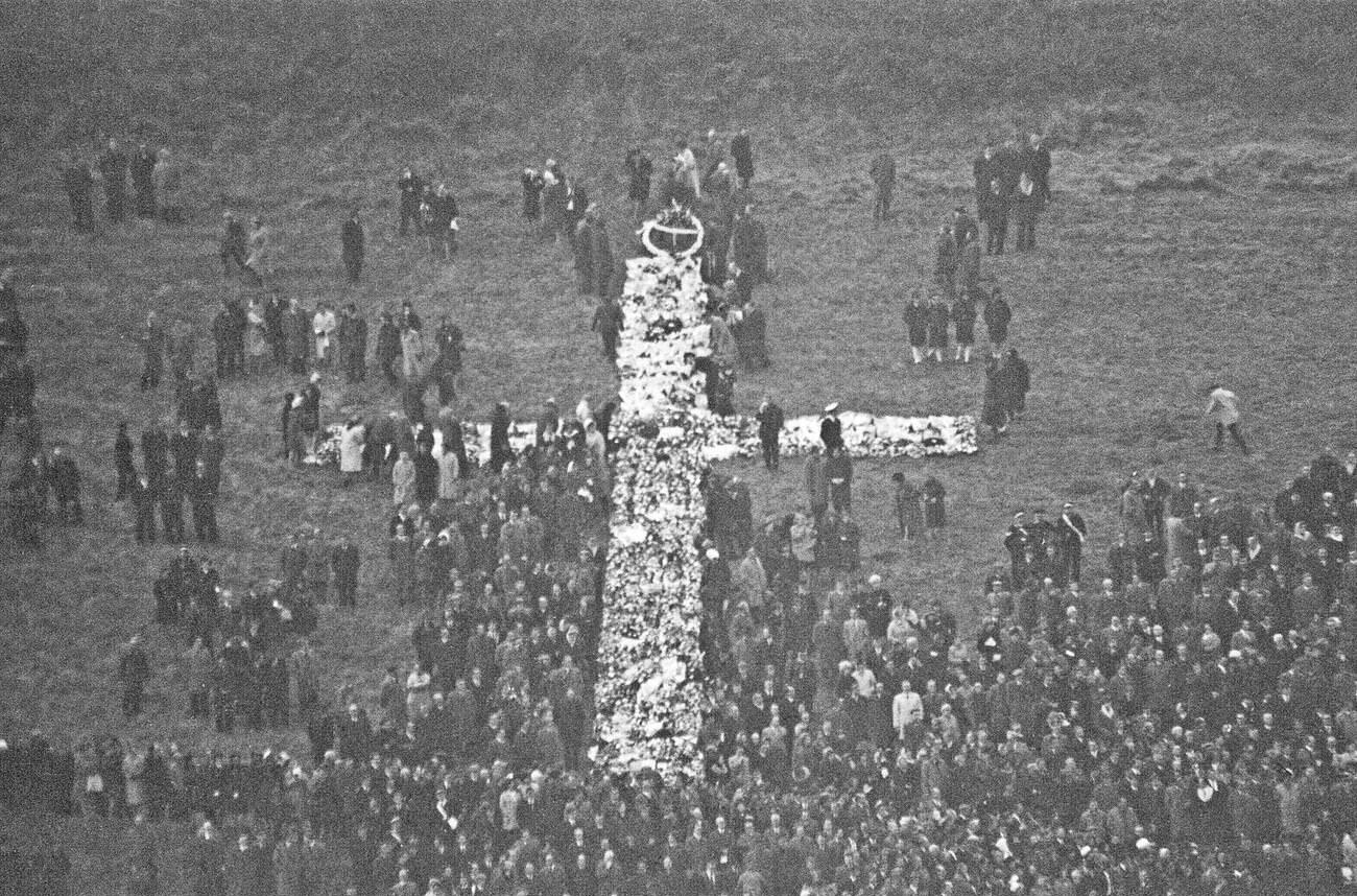 The huge cross of wreaths on the Aberfan hillside cemetery as the funerals take place, 1966.