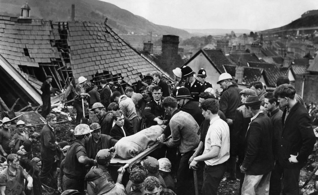 The digging stops as another body is brought from the shattered Pantglas Junior School following the catastrophic collapse of a colliery spoil tip in the Welsh village of Aberfan, killing 116 children and 28 adults, 1966.