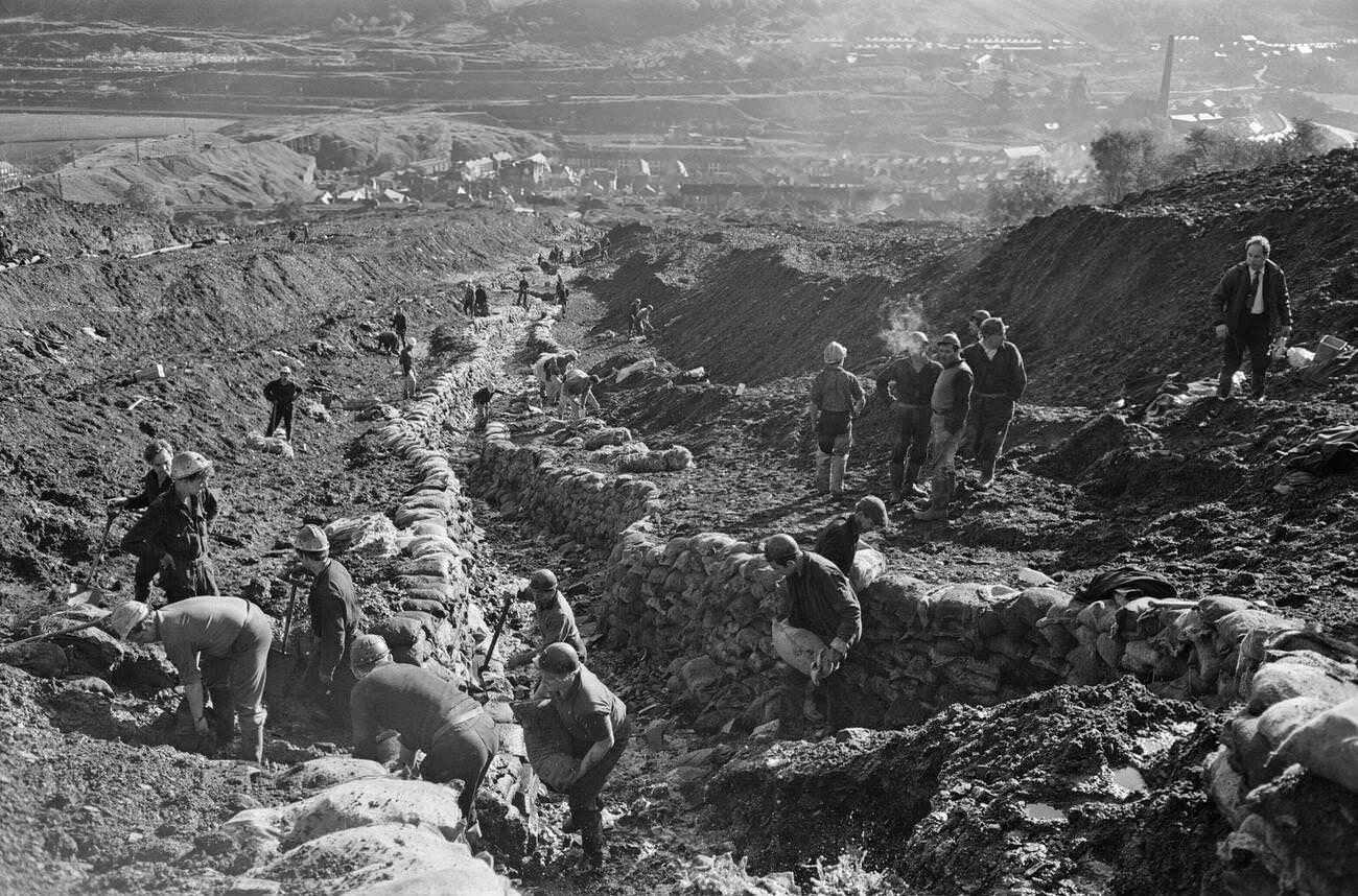 Emergency services and miners on the hillside where the mud slid from, 1966.