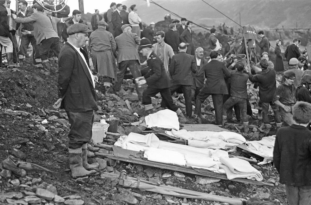 Local men and the emergency services hastily dig through the mud for survivors at the Pantglas Junior School, 1966.