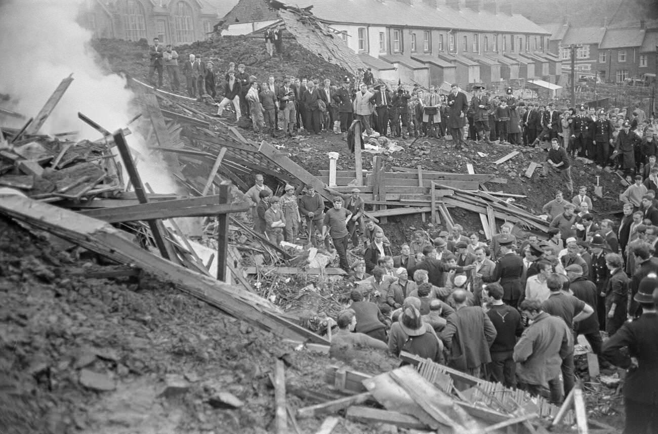 A bonfire is made near to where the mud slide has come to a halt, to burn the wood and wreckage of the school and local houses, 1966.