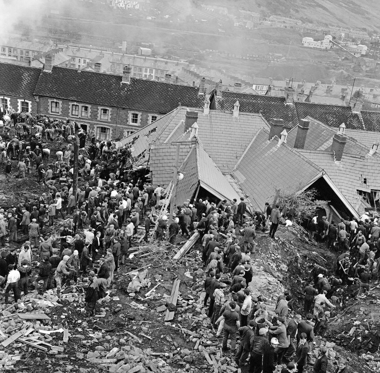 An aerial picture shows the Pantglas Junior School, collapsed under the weight of mud, and the many villagers and emergency services helping to free trapped children and adults, 1966.