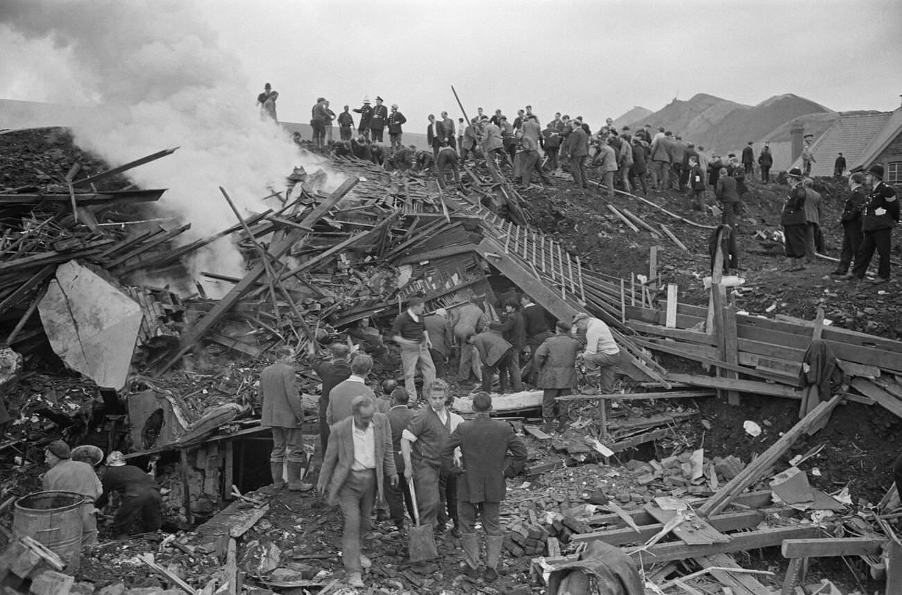 A bonfire is made near to where the mud slide has come to a halt, to burn the wood and wreckage of the school and local houses, 1966.