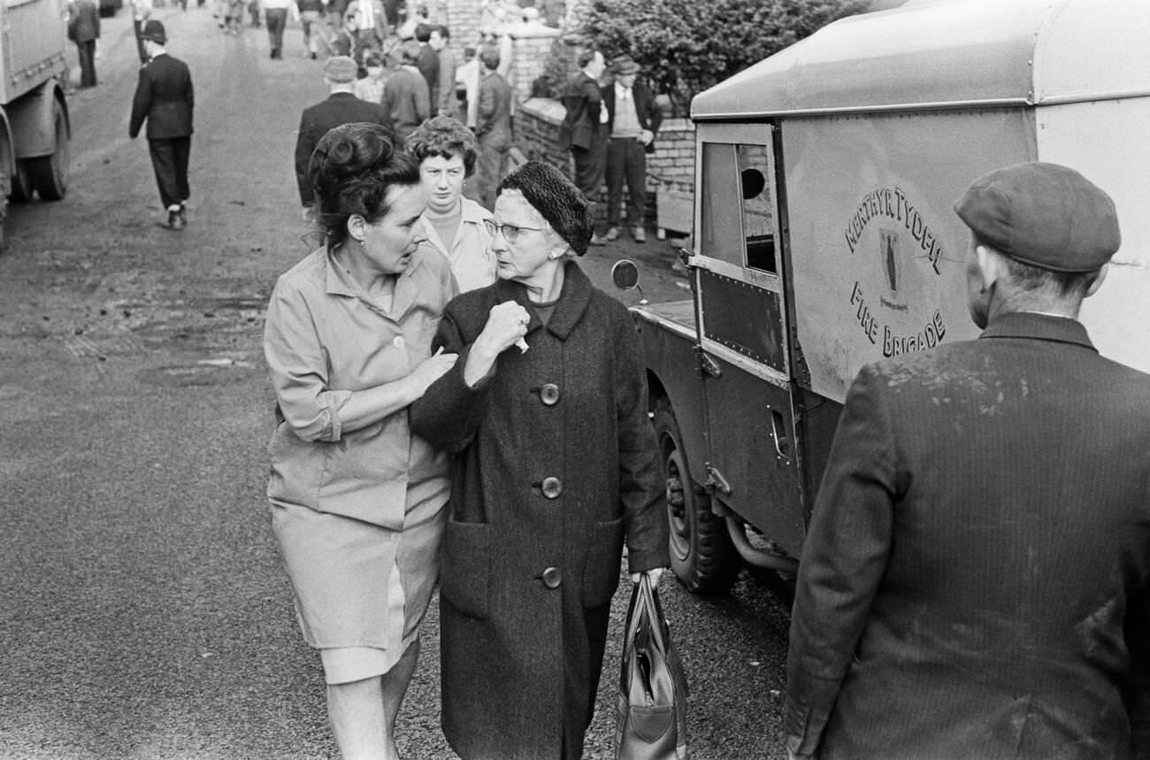 An elderly lady is helped and consoled as she is lead away to safety in the village of Aberfan, 1966.