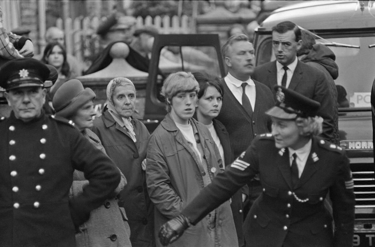 A police woman and policeman trying to restore some calm and order in the village as the rescue effort goes on, 1966.