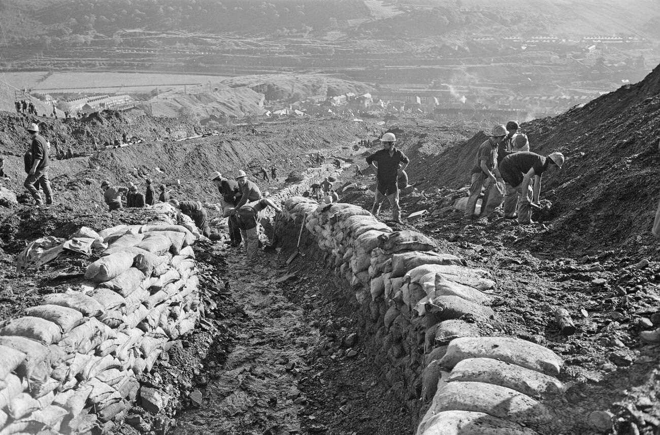 Emergency services and miners on the hillside where the mud slid from, 1966.