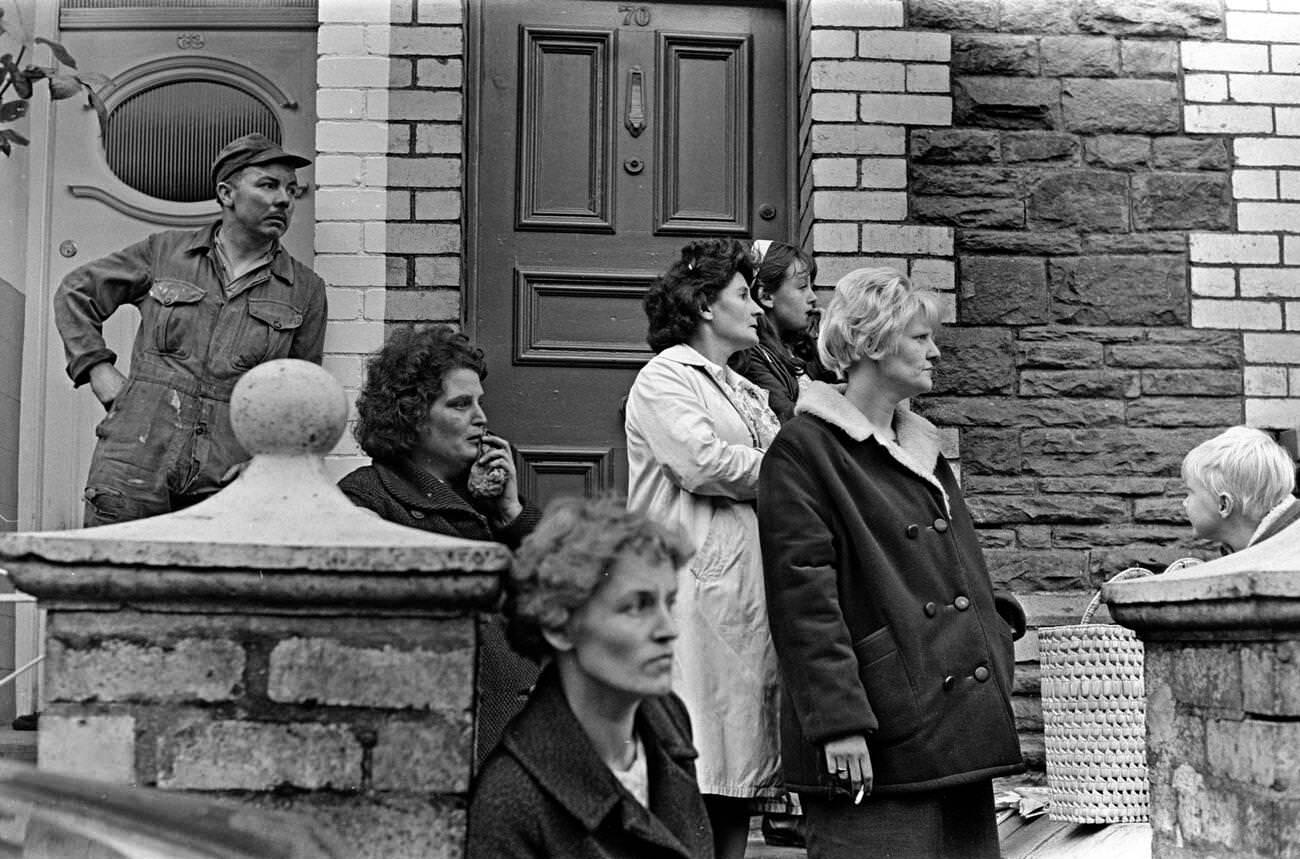 Shocked onlookers look towards the school and the mud and devastation caused when mining spoil from the hillside engulfed the Pantglas Junior School, 1966.