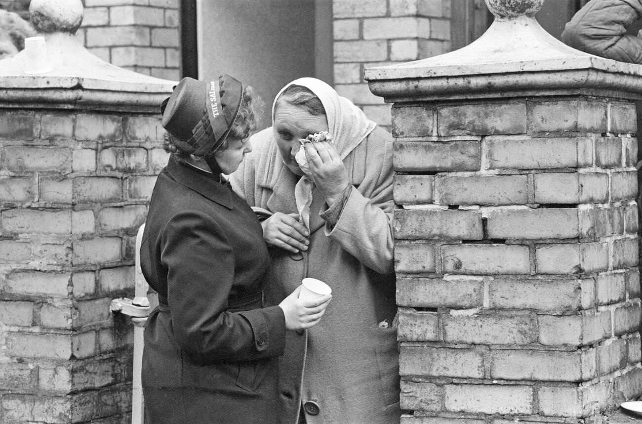 A lady from The Salvation Army consoles an elderly lady who is distraught at the unfolding events in Aberfan, 1966.