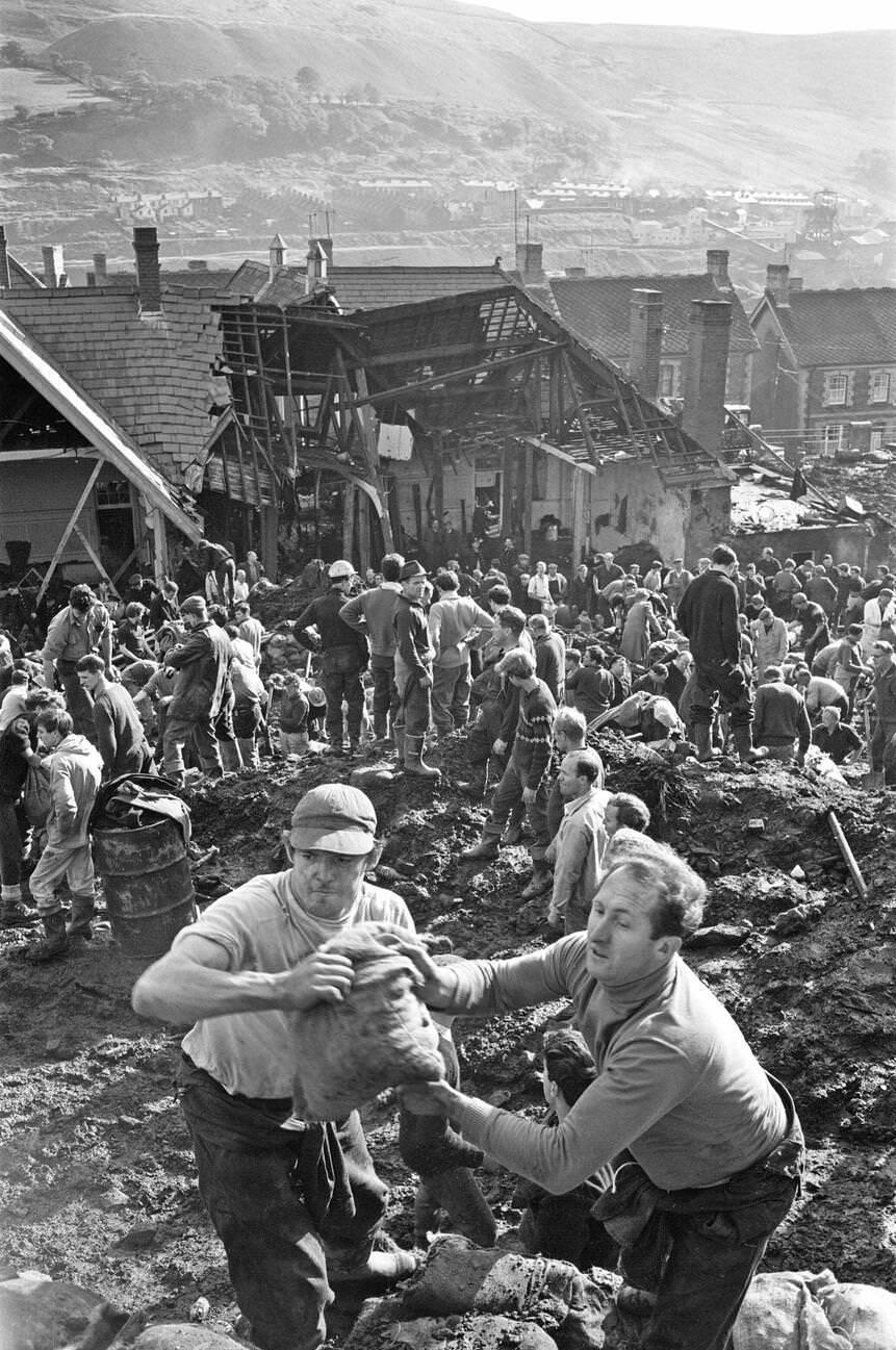 Local men and the emergency services hastily dig through the mud for survivors at the Pantglas Junior School, 1966.