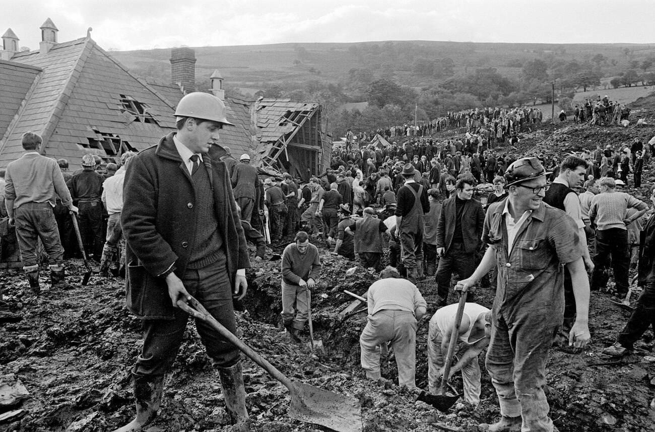 Local men and the emergency services hastily dig through the mud for survivors at the Pantglas Junior School, 1966.