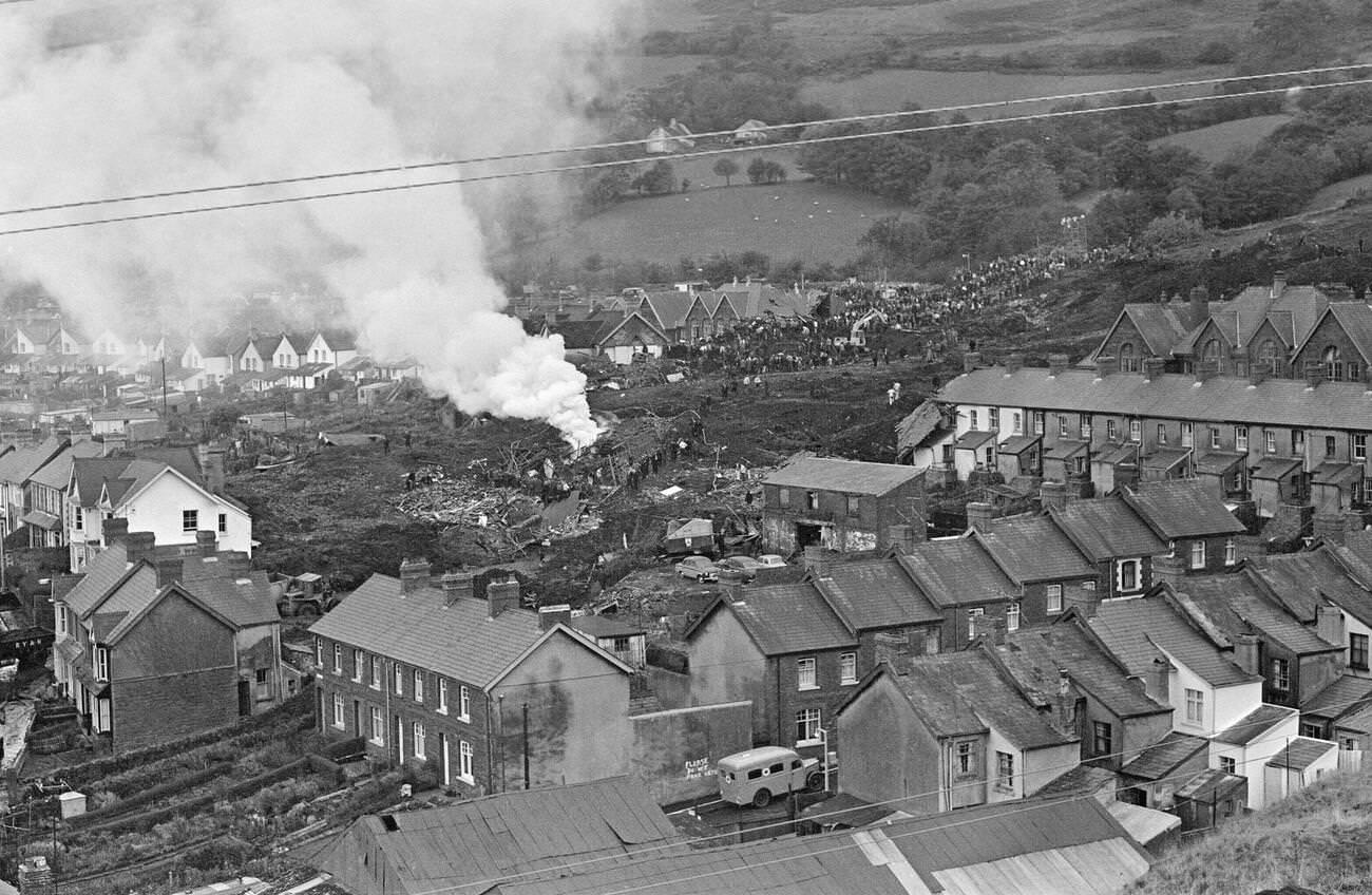 A bonfire is made near to where the mud slide has come to a halt, to burn the wood and wreckage of the school and local houses, 1966.