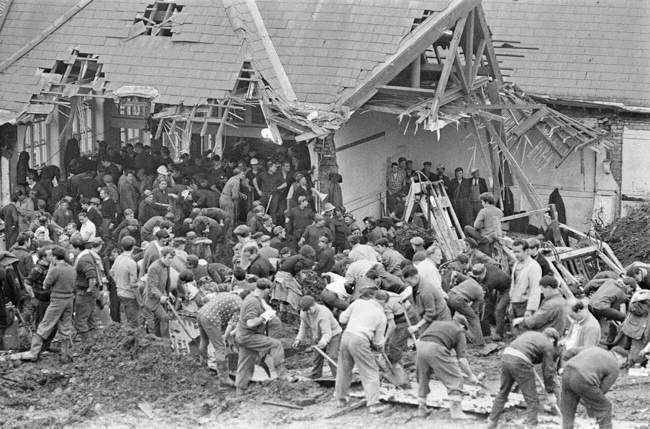 Local men and the emergency services hastily dig through the mud for survivors at the Pantglas Junior School, 1966.