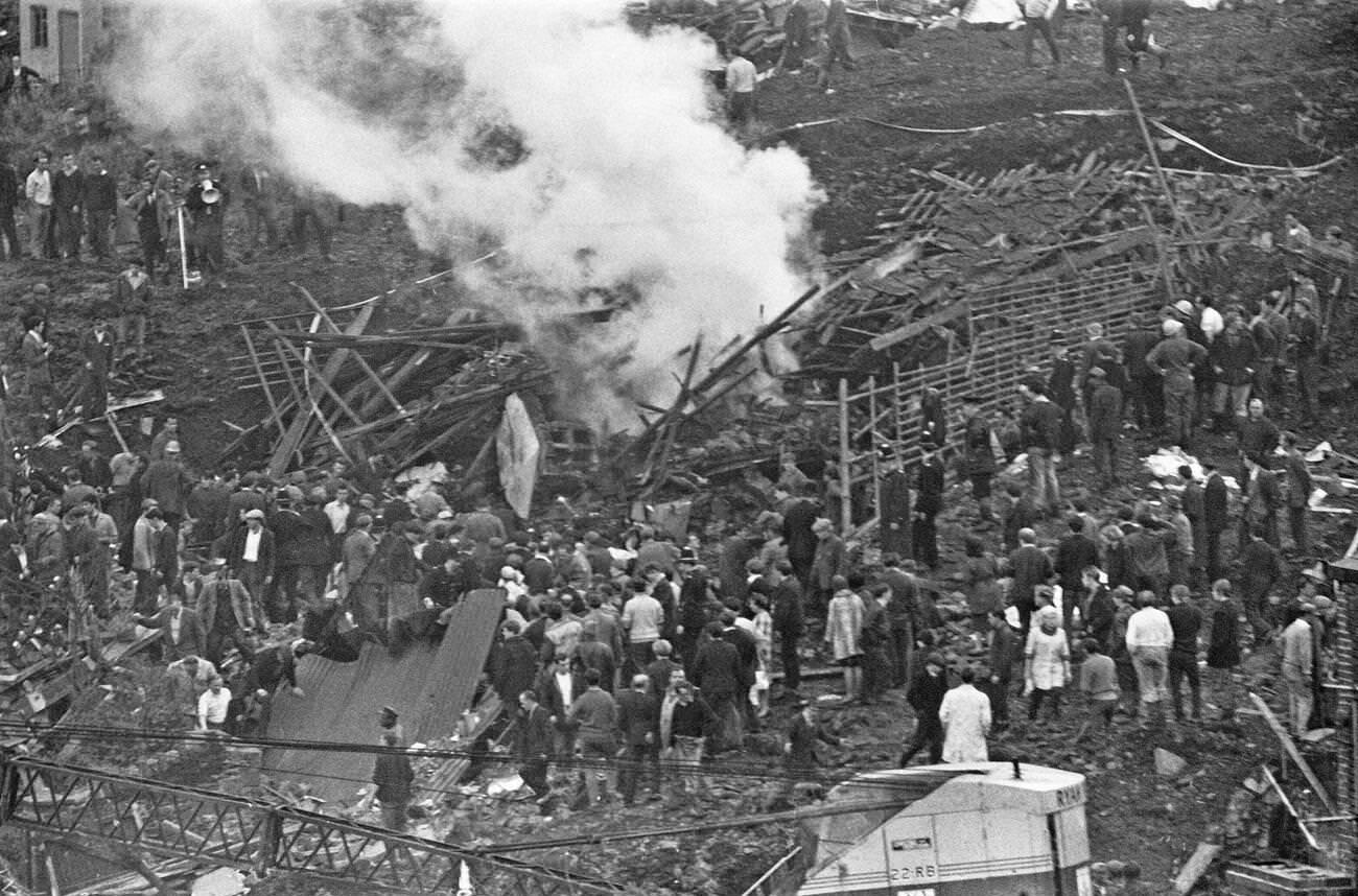 A bonfire is made near to where the mud slide has come to a halt, to burn the wood and wreckage of the school and local houses, 1966.