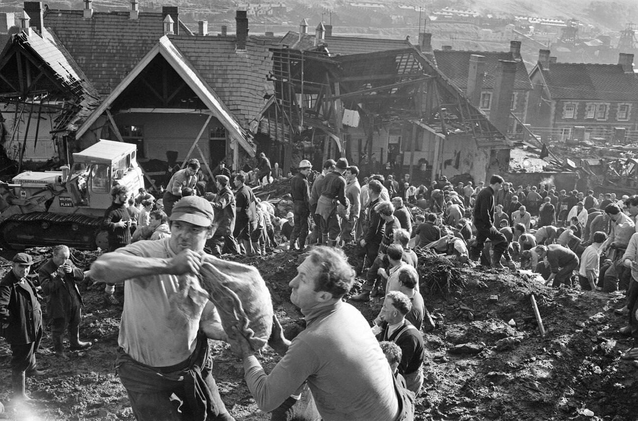 Local men and the emergency services hastily dig through the mud for survivors at the Pantglas Junior School, 1966.