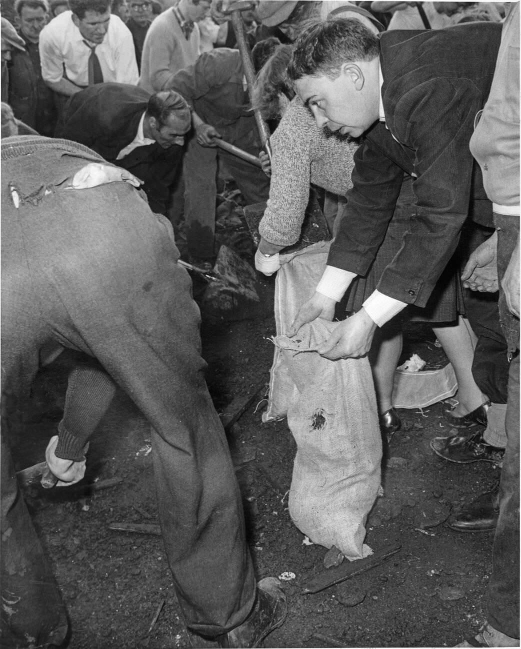 Local men and the emergency services hastily dig through the mud for survivors at the Pantglas Junior School, 1966.