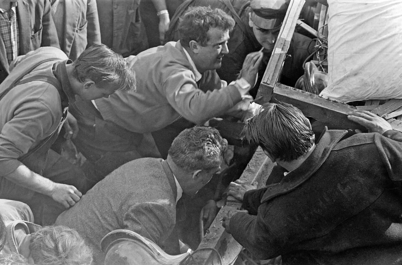 At the Pantglas Junior School, local villagers and emergency services help each other to move wood and obstacles out of the way, hoping to reach those stranded in the mud slide, 1966.