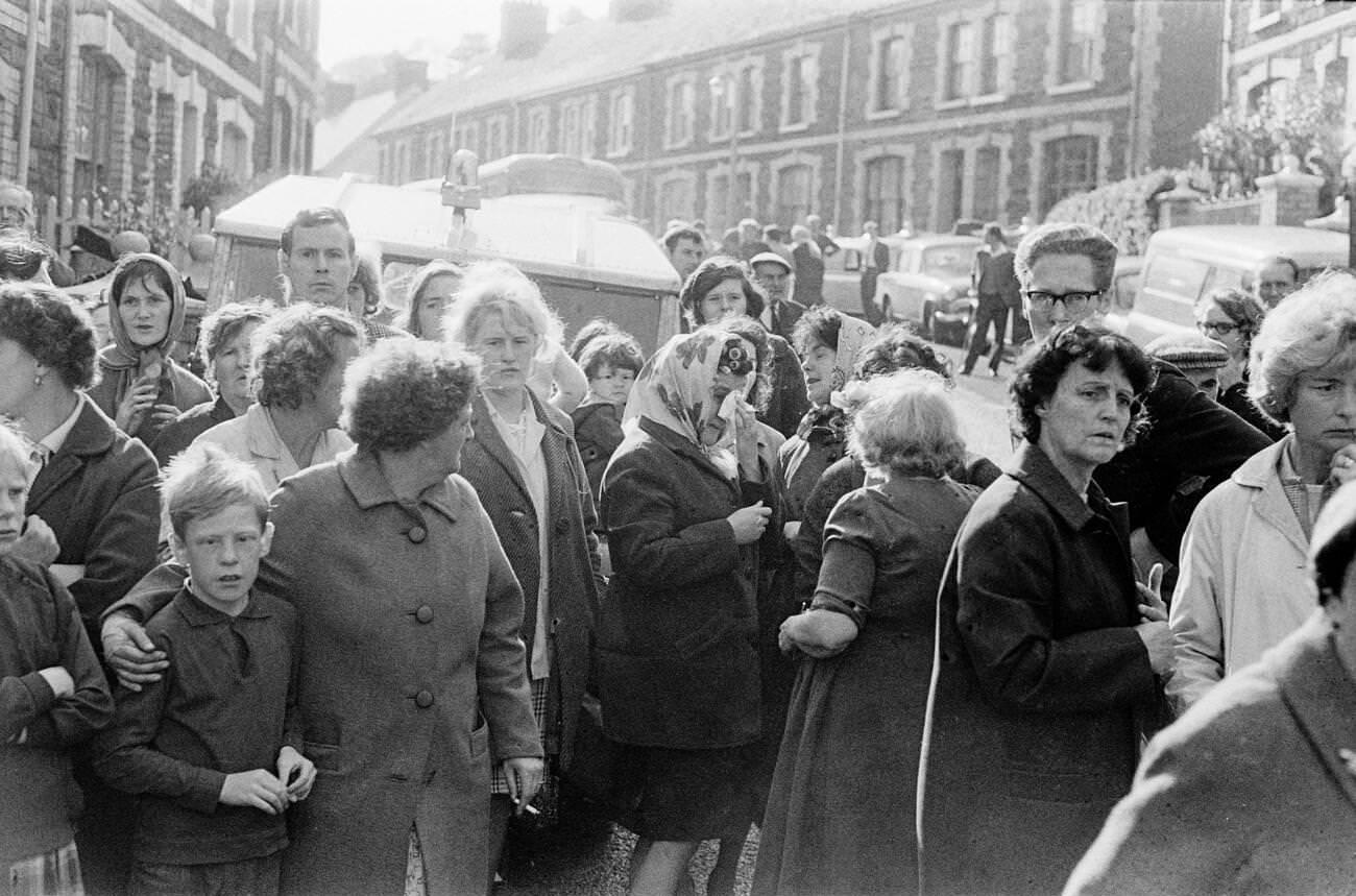 Shocked onlookers look towards the school and the mud and devastation caused when mining spoil from the hillside engulfed the Pantglas Junior School, 1966.