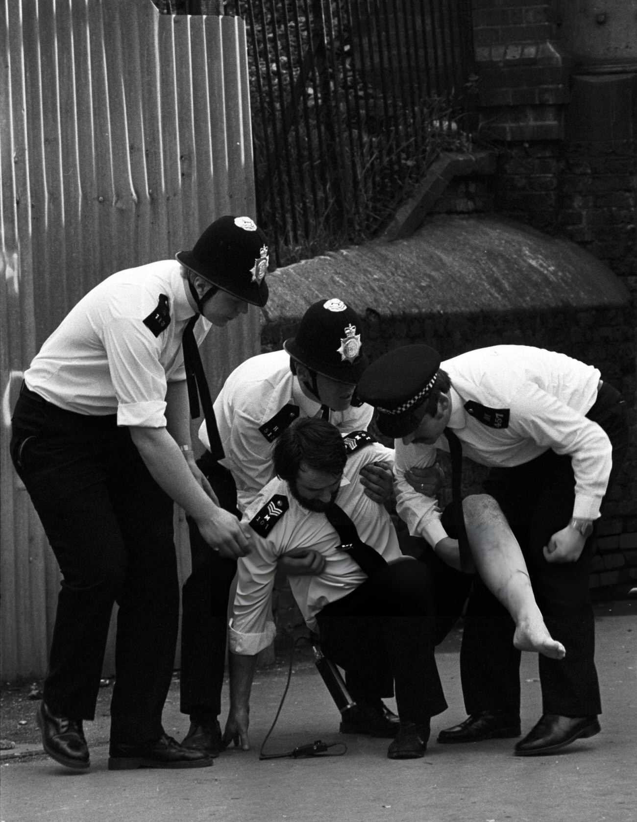 A police sergeant, believed to have been burned by a petrol bomb, being cared for by colleagues at Mayall Road, Brixton, 1981.