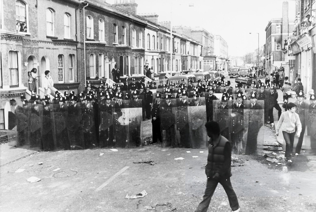 Police take action in the streets of Brixton during the Brixton riots in London, 1981.