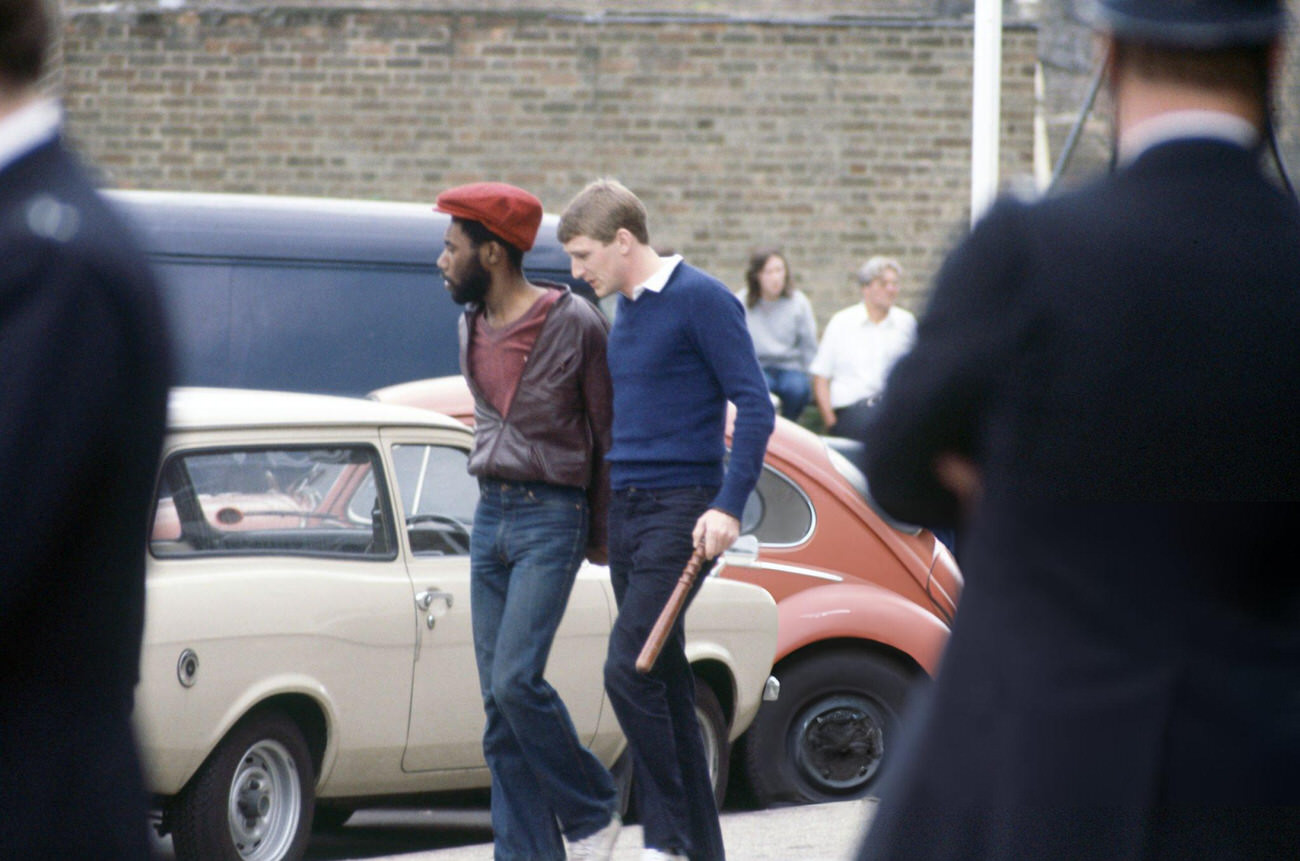 A policeman with a man in custody following the Brixton riots in London on April 11, 1981.