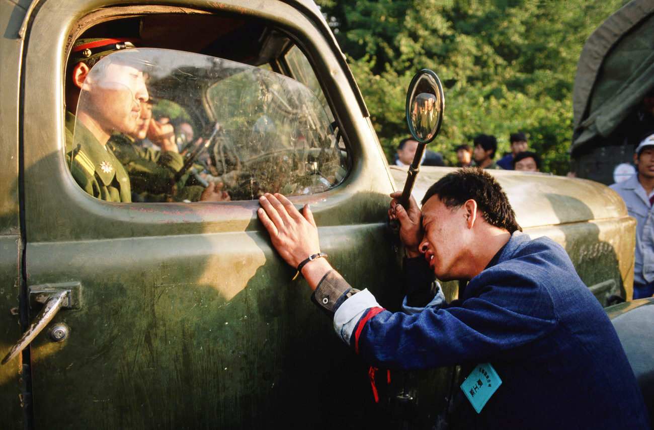 A weary protester pleads with a People's Liberation Army (PLA) officer sitting in his truck to not crack down on the student demonstrators.