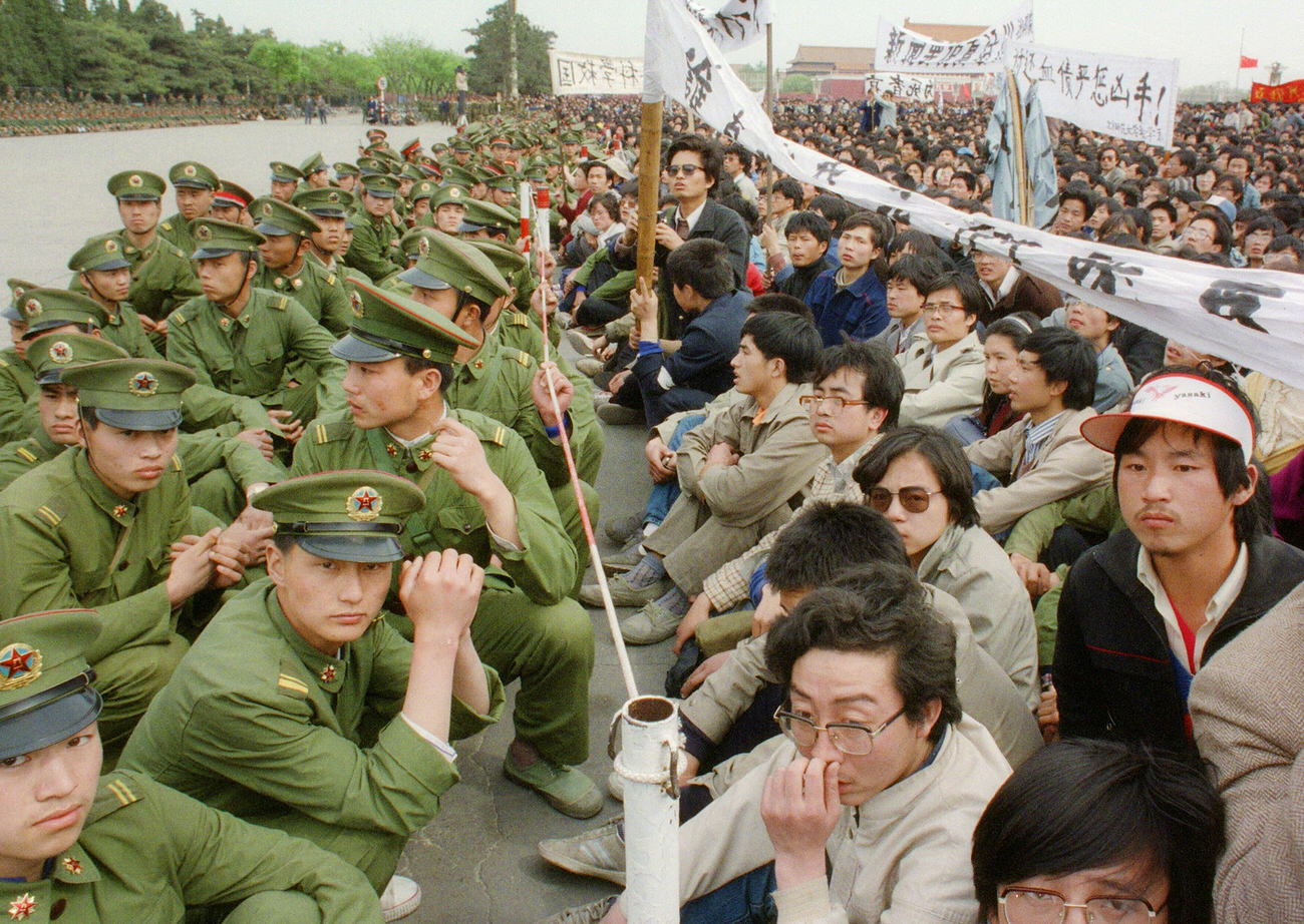 Several hundred pro-democracy student protesters sit face-to-face with police officers outside the Great Hall of the People.