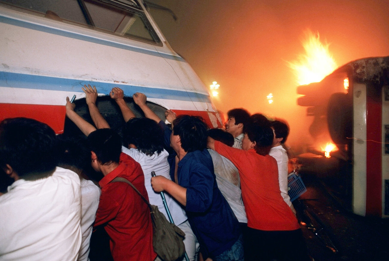 Demonstrators overturn a bus in front of a burning truck on Changan Avenue in order to try to hold up soldiers who were fighting their way toward Tiananmen Square.