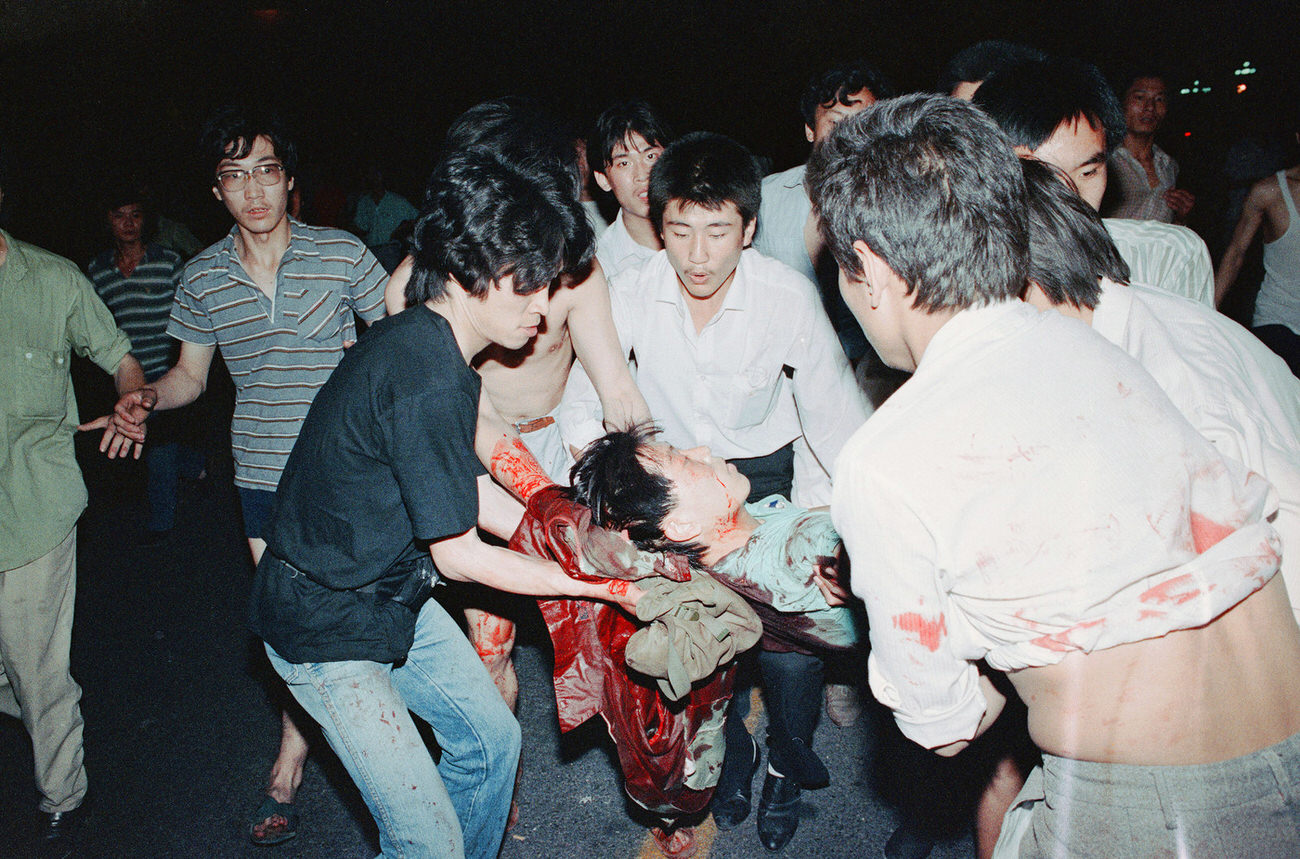 A group of demonstrators come to the aid of an injured man.