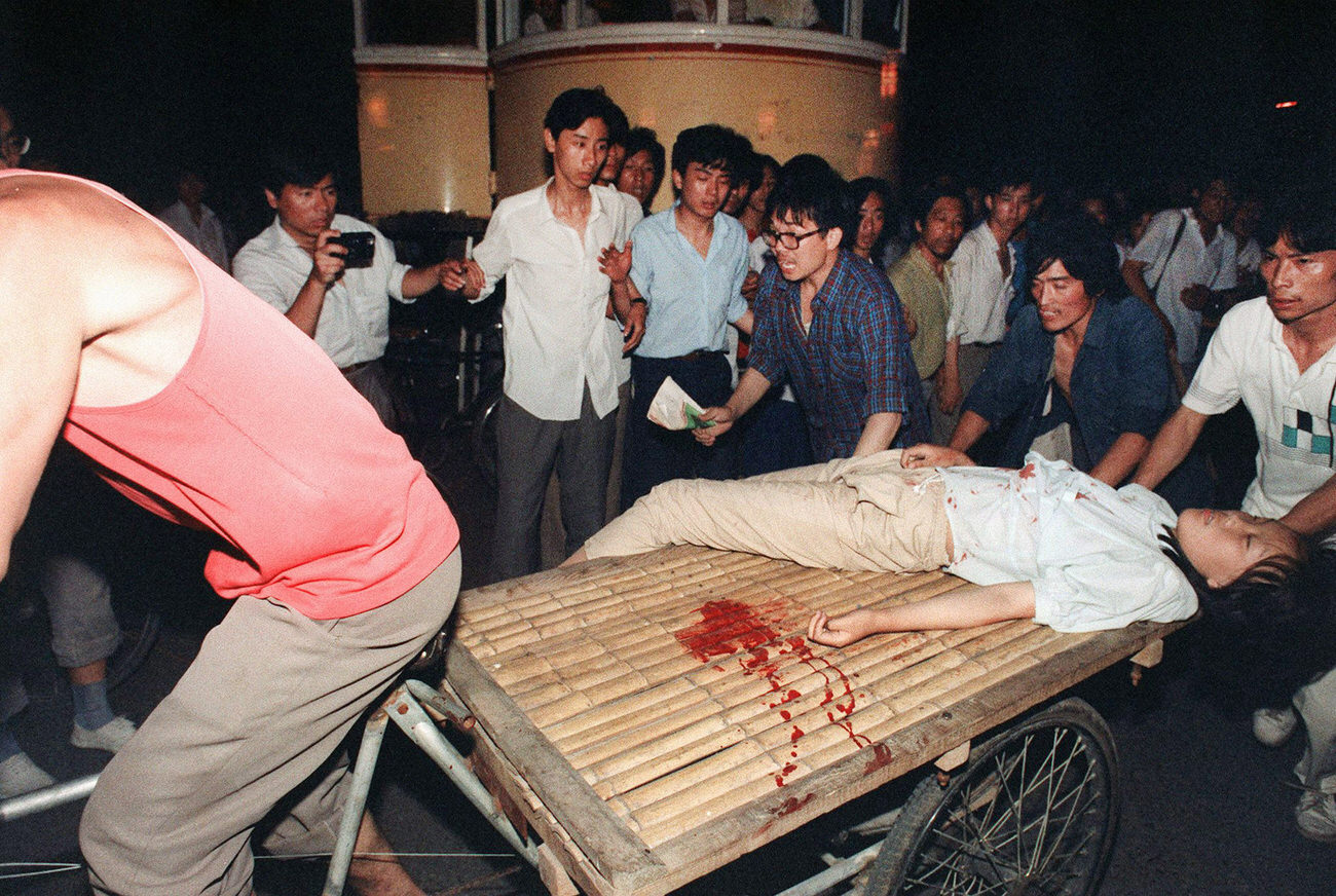 A girl wounded during the clash between the army and students is rushed out of the scene by a cart.