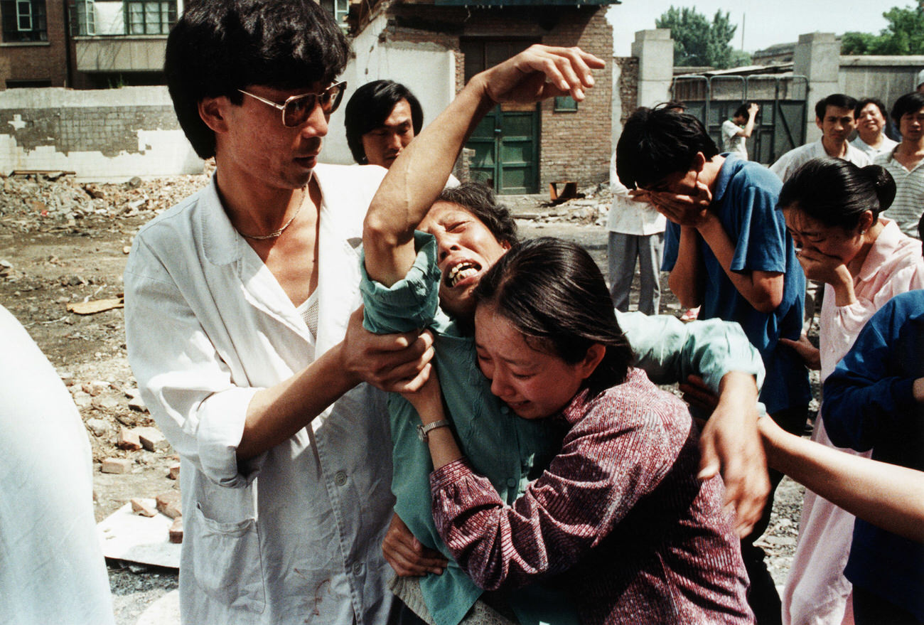 Family members try to comfort a grief-stricken mother who has just learned of the death of her son, a student protester killed by soldiers.