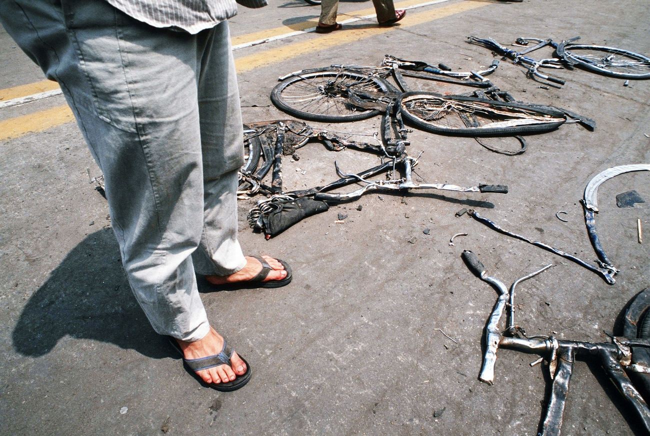 Locals stop to look at bicycles flattened by the Chinese army tanks.