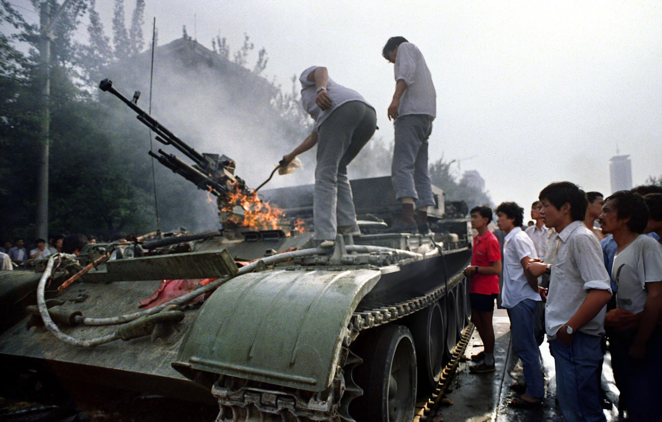 Chinese residents check a burning armored personnel carrier, 1989.