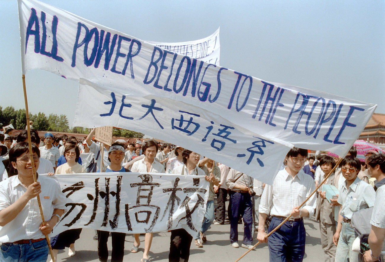 Waving banners, high school students march in Beijing streets near Tiananmen Square on May 25, 1989, during a rally to support the protest against the Chinese government.