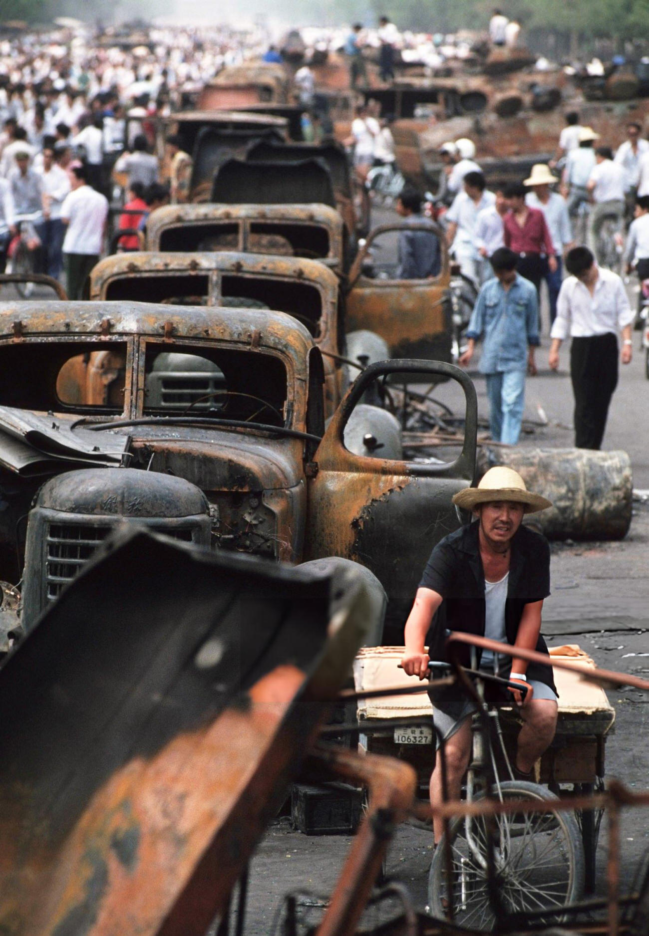 Onlookers examine Chinese Army trucks and vehicles that were damaged or destroyed, 1989.