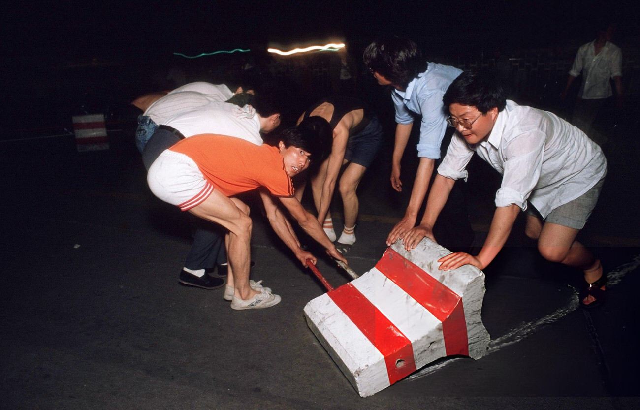 Pro-democracy demonstrators pull barricades across Changan Avenue, 1989.