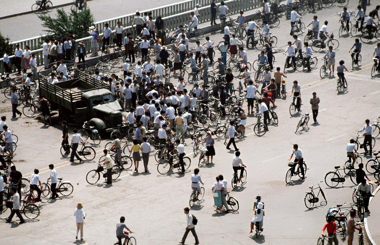 Onlookers view Chinese Army trucks and vehicles that were damaged or destroyed, 1989.