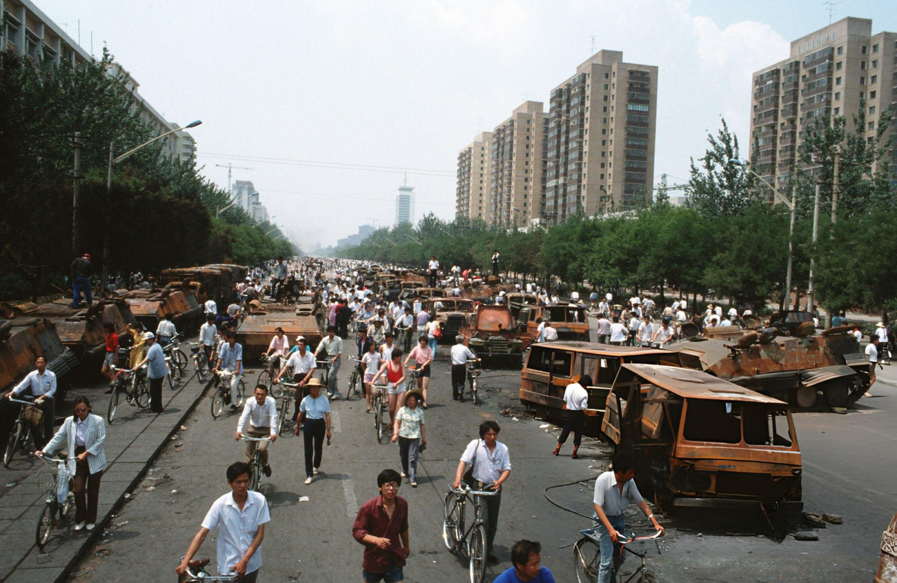 Onlookers examine Chinese Army trucks and vehicles that were damaged or destroyed, 1989.