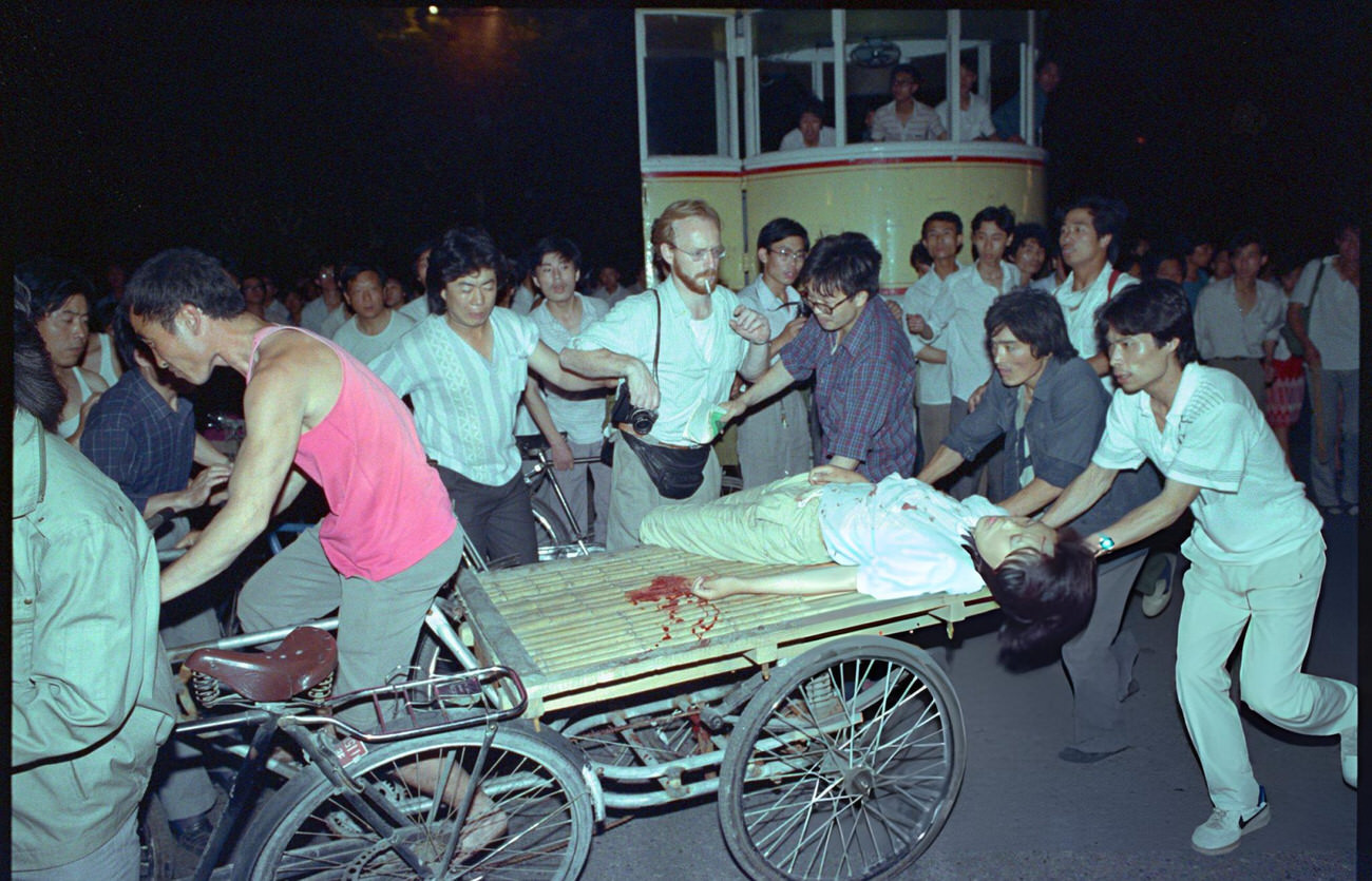 People transport a wounded woman, 1989.