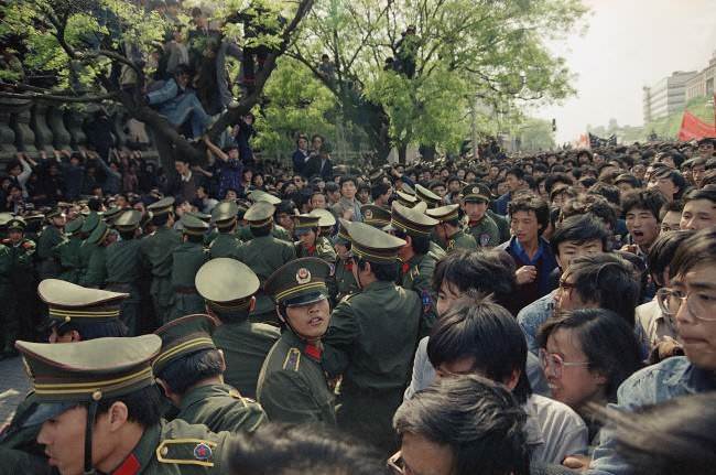 Students demonstrators scuffle with police as they try to break the guard line to march to the Tiananmen Square on Thursday, April 27, 1989 in Beijing.