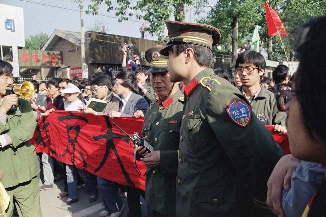 Chinese police try in vain to convince students from Beijing University not to march as they emerged from their campus on Thursday, April 27, 1989 in Beijing.