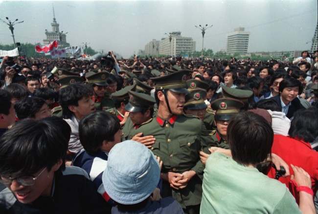 Calling for freedom and democracy, demonstrating students surround policemen near Tiananmen Square in Beijing, China, Thursday afternoon on May 4, 1989. Approximately 100,000 students and workers marched toward the square demanding democratic reforms.