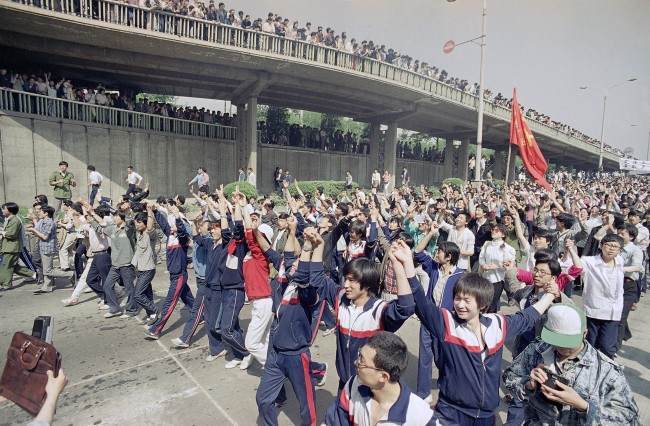 Students of Teachers University raise their hands to appeal to supporting citizens near Tiananmen Square, Thursday, May 4, 1989 in Beijing.