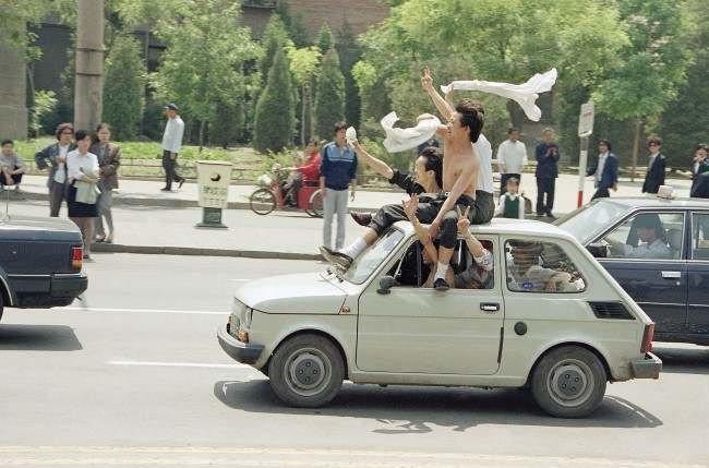 Beijing youths ride atop a car as they parade to Tiananmen Square for a freedom rally, Wednesday, May 17, 1989 in Beijing.